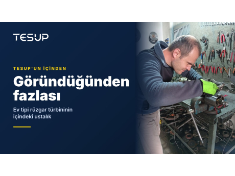 Alet dolu bir duvarın önündeki tezgâhta jeneratör rotoru ve milini monte eden bir TESUP teknisyeni; başlık: göründüğünden fazlası, ev tipi bir rüzgar türbininin içindeki ustalık