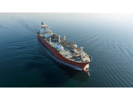 A gas tanker under way on open sea, seen from above with its wake behind it