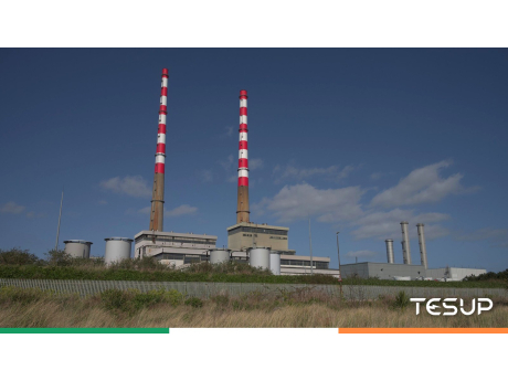 As chaminés vermelhas e brancas de Poolbeg na baía de Dublin sob um céu azul, com uma fita nas cores da bandeira irlandesa