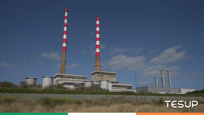 The red-and-white Poolbeg chimneys on Dublin Bay under a blue sky, with an Irish tricolour ribbon