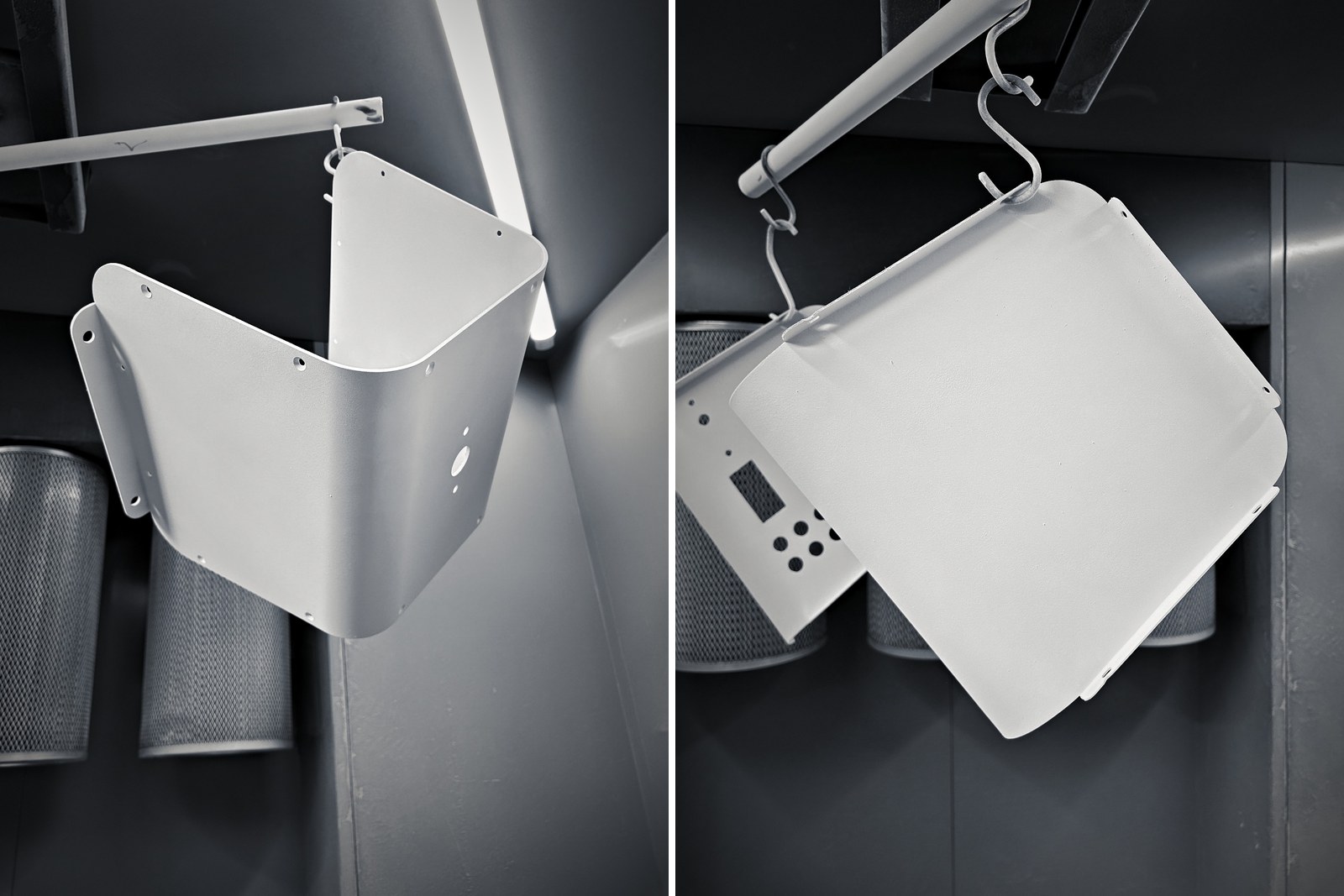 Two white powder-coated Atlas body panels hanging in the powder-coating booth