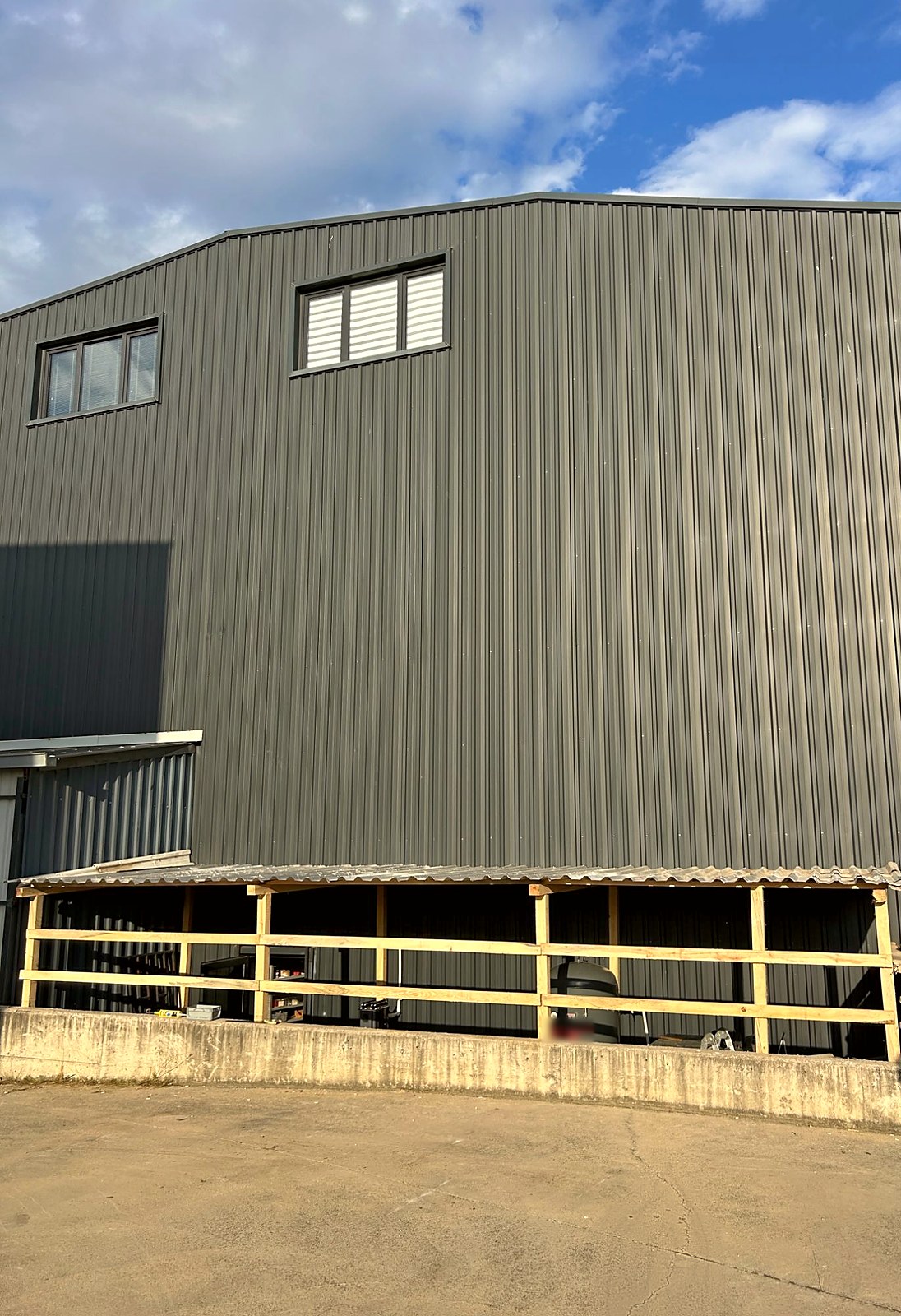 The production hall seen from the yard, with the new compressor shelter along the bottom of the wall