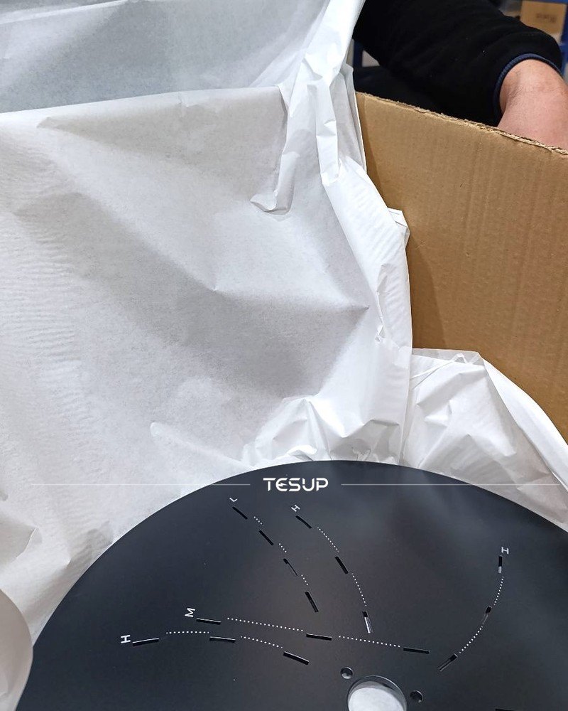 A TESUP flange being packed carefully in protective paper inside a shipping box
