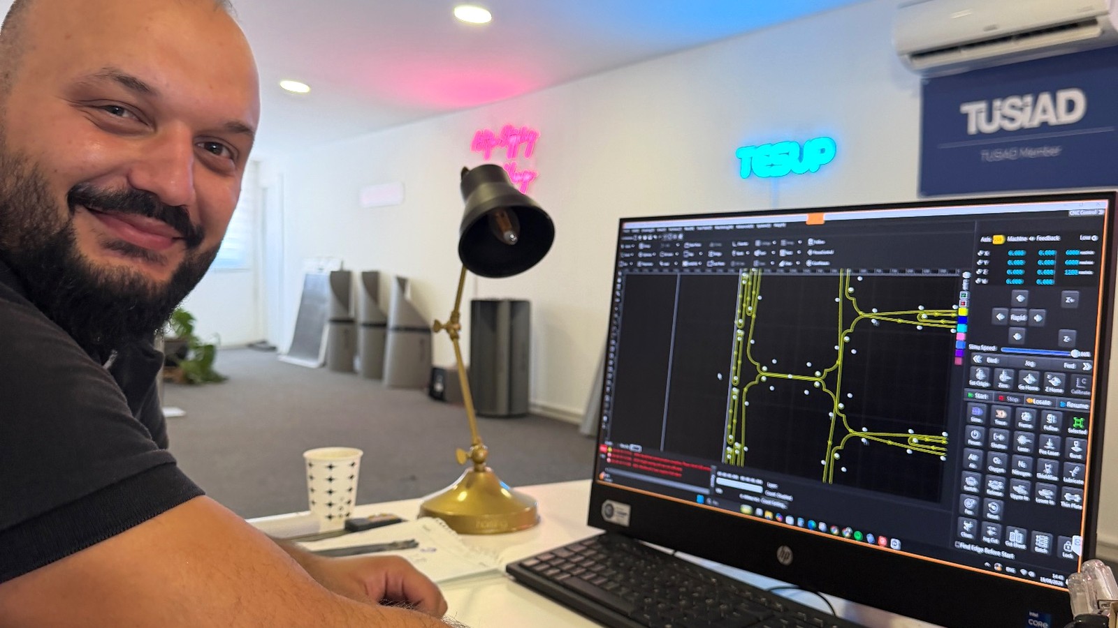 A TESUP engineer at the CNC control screen, cutting paths and pierce points visible on the monitor