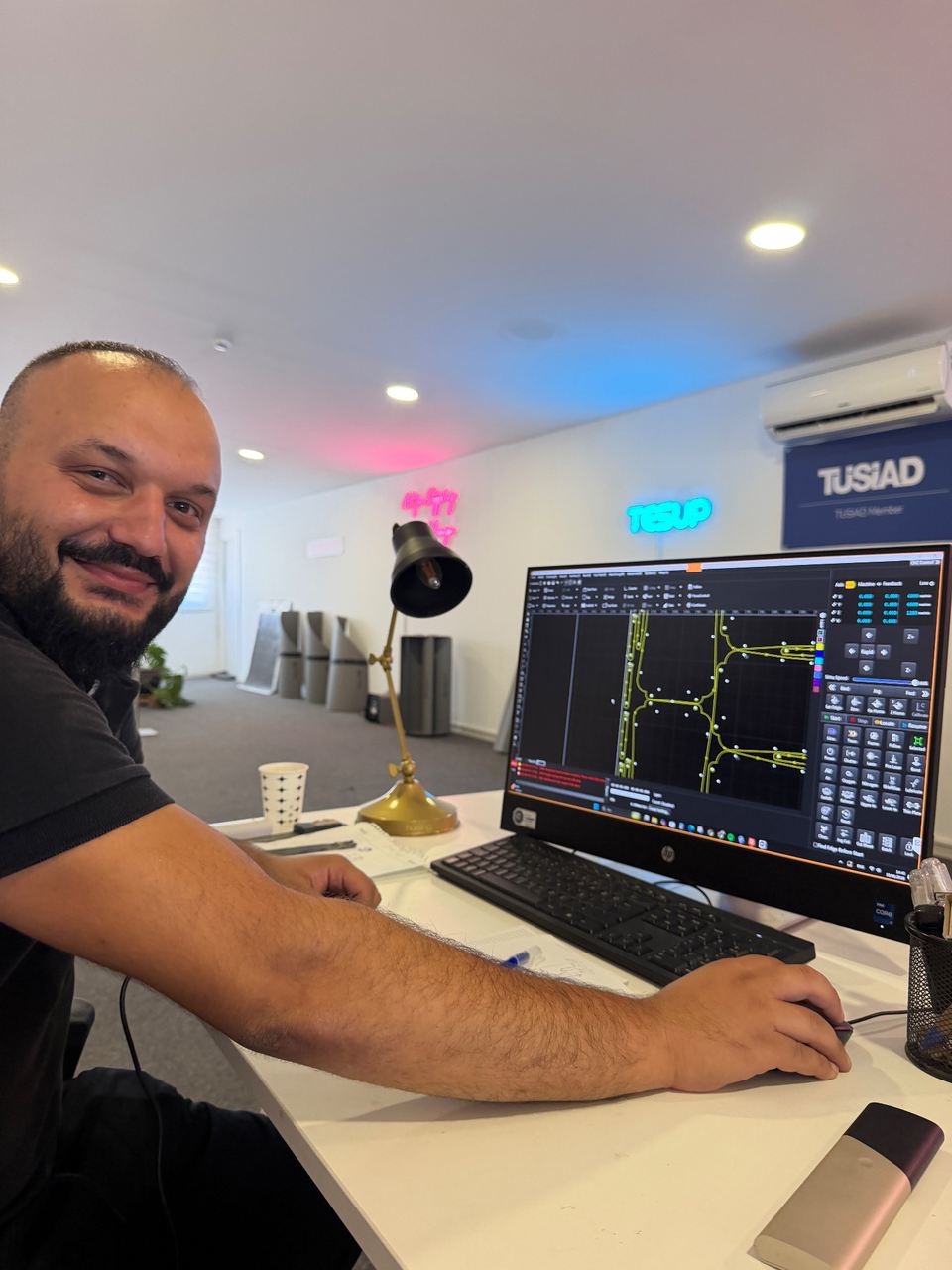 TESUP technician Okan Gumus at the CNC control screen, cutting paths and pierce points visible on the monitor