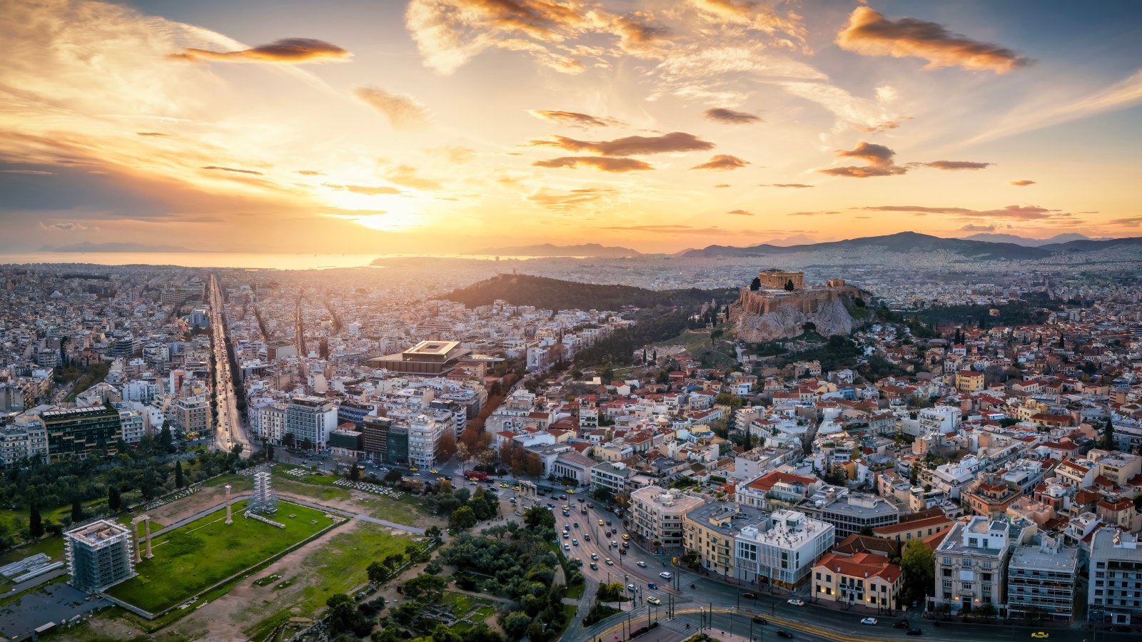 Athens at sunset, with the city spreading out below the hills of Attica