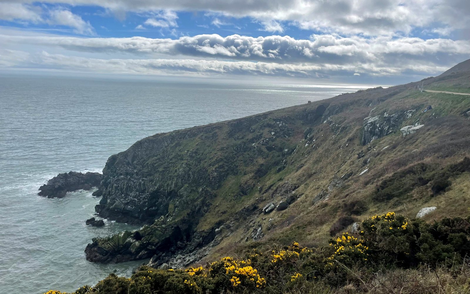 O trilho das falésias de Howth Head sobre o mar da Irlanda, sob um céu luminoso e com nuvens